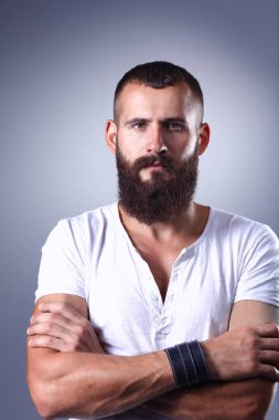 Ayakta, gri arka plan üzerinde izole yakışıklı adam portresi