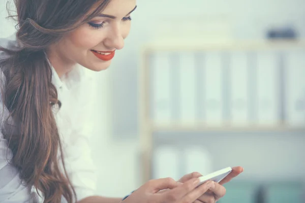 Geschäftsfrau verschickt Nachricht mit Smartphone im Büro — Stockfoto