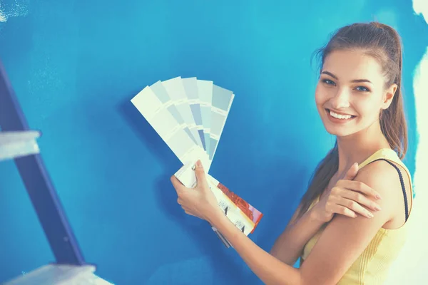 Joven hermosa mujer sosteniendo paleta con muestras de colores — Foto de Stock