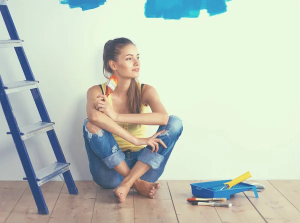 Portrait de peintre femme assise sur le sol près du mur après la peinture — Photo