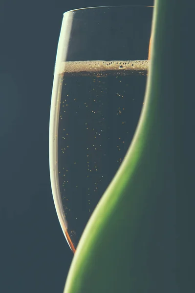 Glas wijn en een fles op zwarte achtergrond — Stockfoto