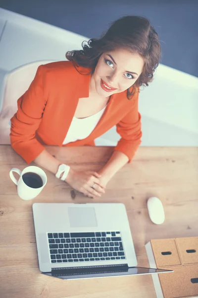 Attraktiv kvinna sitter vid skrivbordet på kontoret, arbetar med bärbar dator — Stockfoto