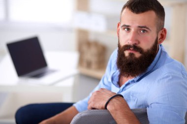 Genç işadamı koltukta oturuyor.