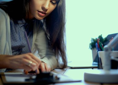 Masada oturan genç bir kadın.