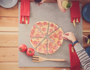 Bir grup insan pizza yemek.
