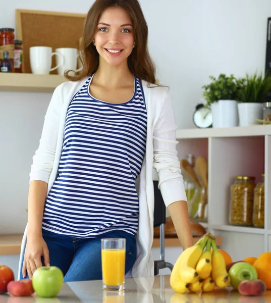 Young woman sitting near desk in the kitchen — Stock Photo, Image