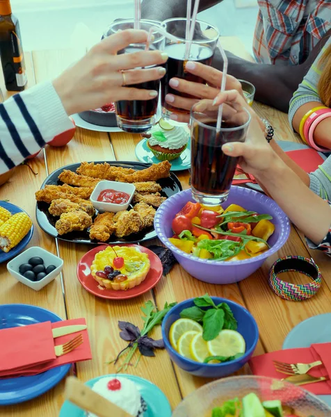 Pessoas com bebidas enquanto se sentam na mesa de jantar — Fotografia de Stock