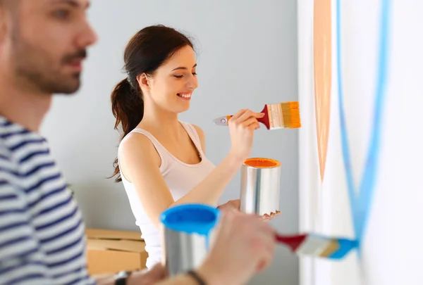 Pareja joven pintando pared en casa —  Fotos de Stock