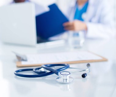 Tıp doktorları masada çalışıyor. Steteskopa odaklan..