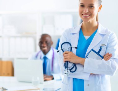 İçerde üniforması olan gülümseyen bir kadın doktor.