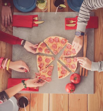 Bir grup insan pizza yemek.