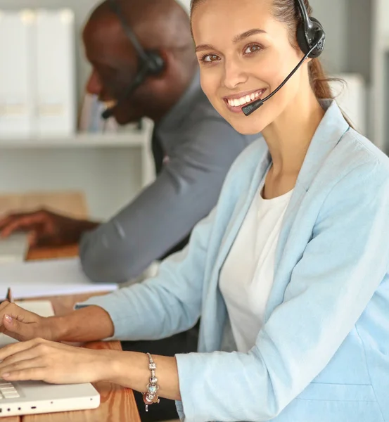 Gente de negocios con auriculares usando computadoras en la oficina —  Fotos de Stock