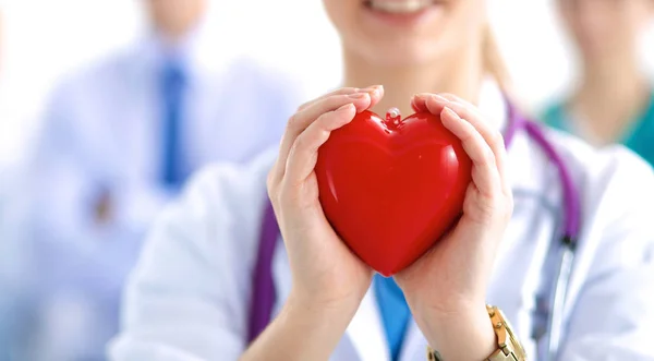 Female doctor with stethoscope holding heart — Stock Photo, Image