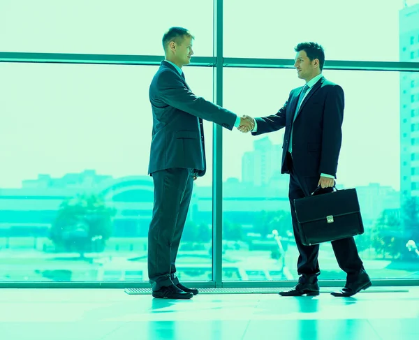 Imagen completa de dos exitosos hombres de negocios estrechándose la mano entre sí —  Fotos de Stock