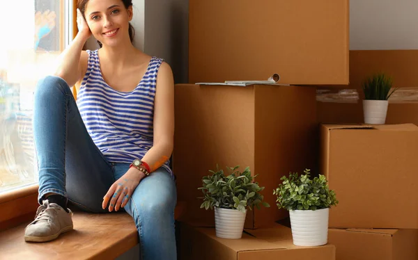 Chica sentada en el alféizar de la ventana en el nuevo hogar — Foto de Stock