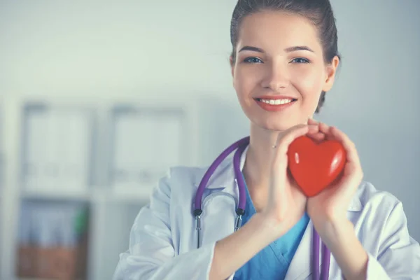 Jeune femme médecin tenant un cœur rouge — Photo