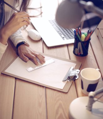 Masada oturan genç bir kadın.