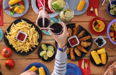 Yemek masasında içki içen insanlar.