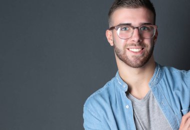 Genç adam ayakta beyaz arka plan üzerinde izole çanta ile