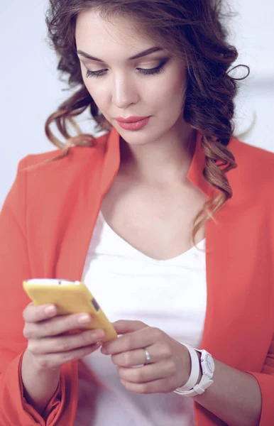 Mulher de negócios bonita usando telefone celular de pé no escritório — Fotografia de Stock