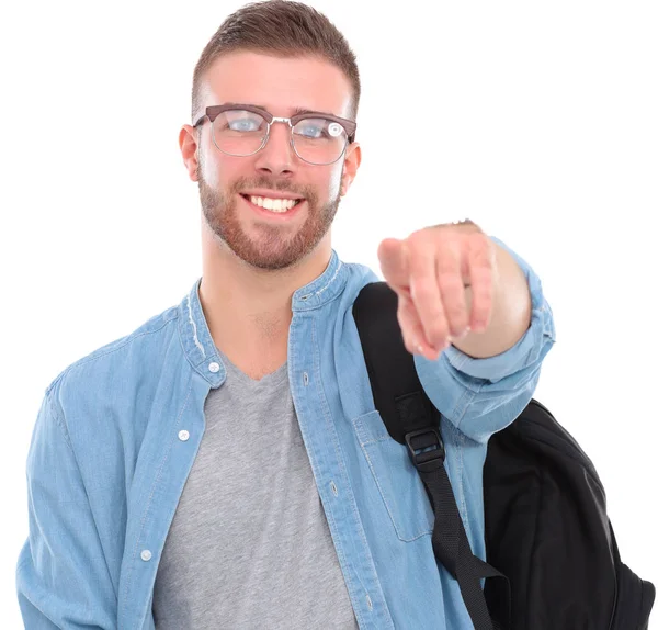 Joven estudiante masculino con una bolsa de la escuela sosteniendo libros y señalándote aislado sobre fondo blanco — Foto de Stock