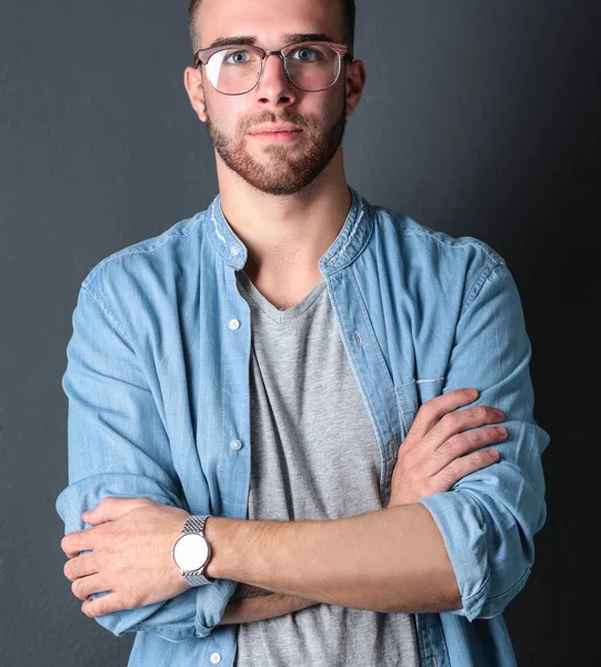 Retrato de homem casual feliz de pé isolado em um fundo escuro — Fotografia de Stock