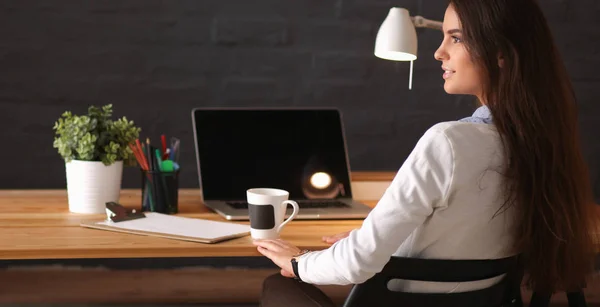 Retrato mujer joven relajada sentada en su escritorio sosteniendo taza de café —  Fotos de Stock