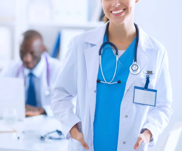 En leende kvinnlig läkare med en mapp i uniform inomhus — Stockfoto