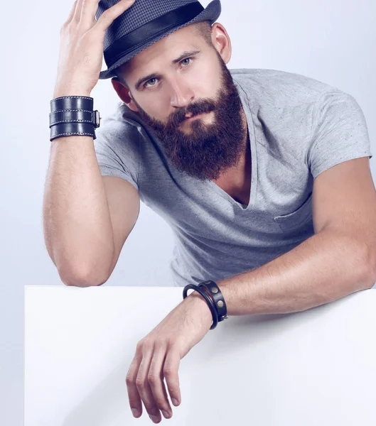 Portrait of young man in hat standing near blank, isolated on white background — Stock Photo, Image