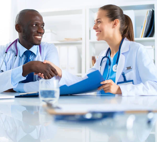 Dos jóvenes médicos sonrientes felices apretones de manos en la oficina — Foto de Stock