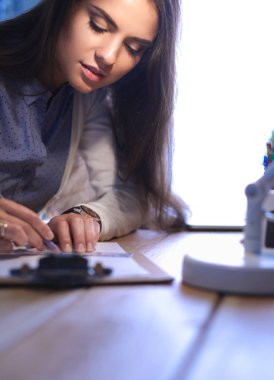 Masada oturan genç bir kadın.