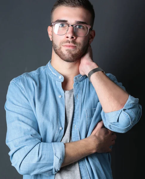 Retrato de hombre casual feliz de pie aislado sobre un fondo oscuro . — Foto de Stock