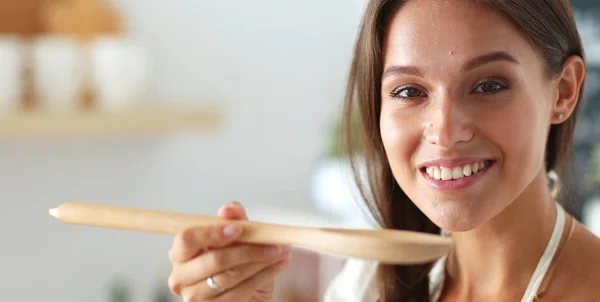 Mujer cocinera en cocina con cuchara de madera —  Fotos de Stock