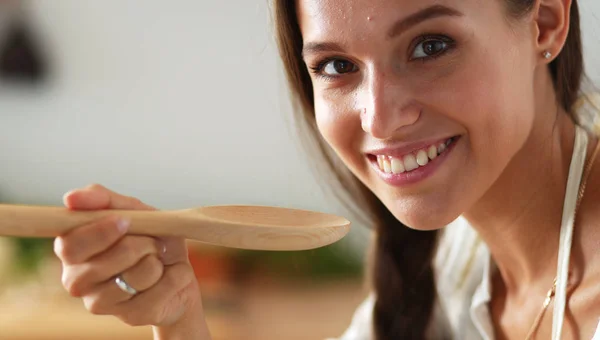 Mujer cocinera en cocina con cuchara de madera —  Fotos de Stock