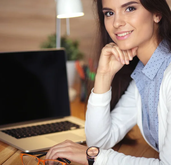 Giovane donna che lavora seduta ad una scrivania — Foto Stock