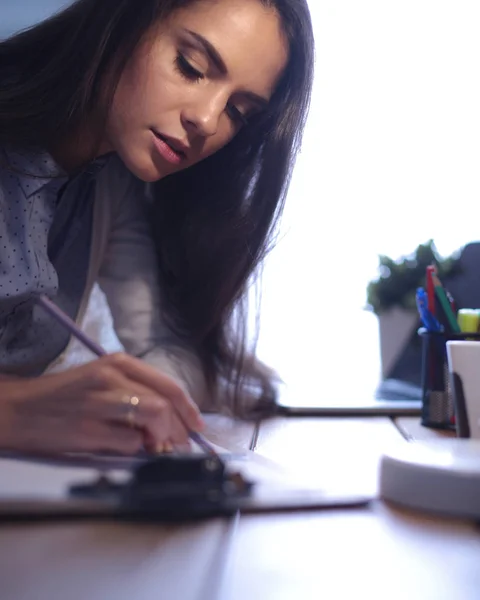 Joven mujer trabajando sentada en un escritorio —  Fotos de Stock