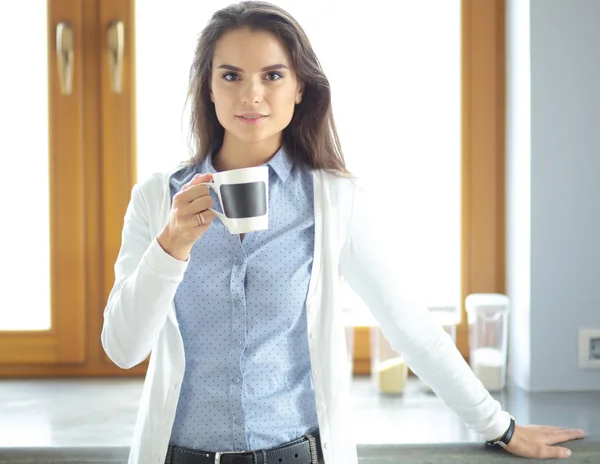 Donna felice bere il tè in cucina a casa — Foto Stock