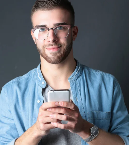 Ler ung man hålla telefonen medan textmeddelanden — Stockfoto