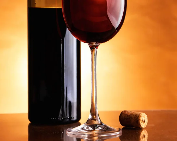 Glass of wine and a bottle on black background — Stock Photo, Image