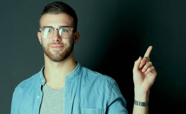 Genç adam gri arka plan üzerinde bir kredi kartı ayakta tutan.