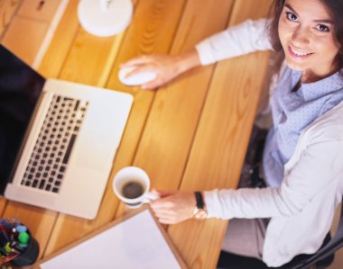 Masada oturan genç bir kadın.