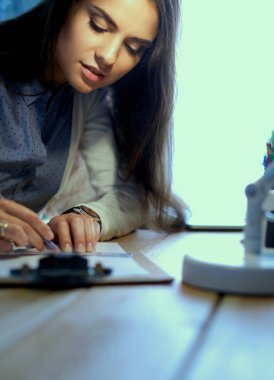Masada oturan genç bir kadın.
