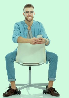 Genç adam ayakta beyaz arka plan üzerinde izole çanta ile