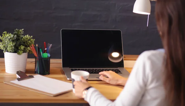 Jonge vrouw werkend zittend aan een bureau — Stockfoto