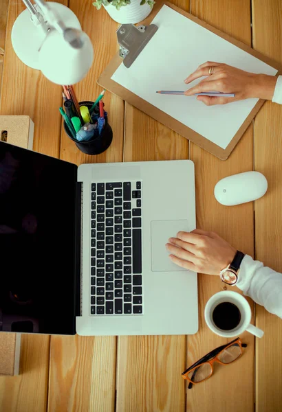 Jeune femme travaillant assise à un bureau — Photo