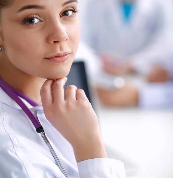 Belle jeune femme médecin souriante assise au bureau — Photo