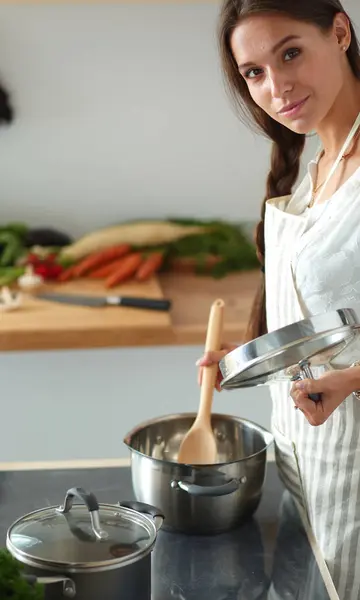 Cooking woman in kitchen with wooden spoon — Stock Photo, Image