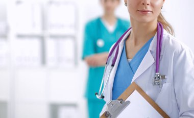 Kadın doktor hastanede dosyayla bekliyor.