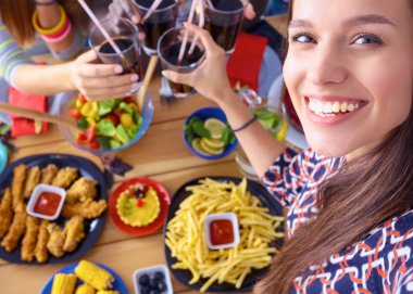 Öğle yemeği sırasında selfie çeken bir grup insan.