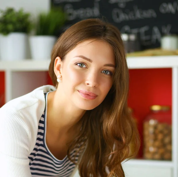 Giovane donna seduta vicino alla scrivania in cucina — Foto Stock